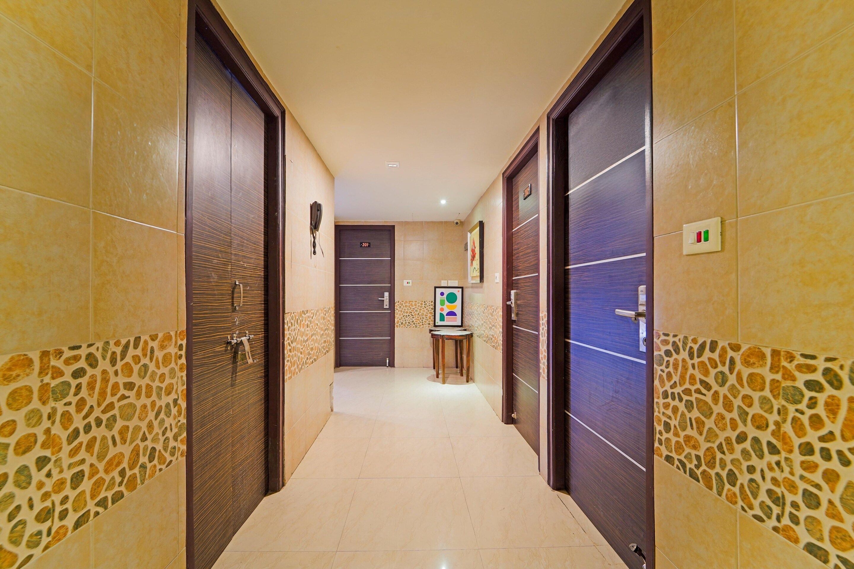 A hotel corridor with two doors, a reception desk, and a small table with a chair.