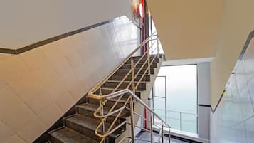 A staircase with metal handrails and a tiled wall.