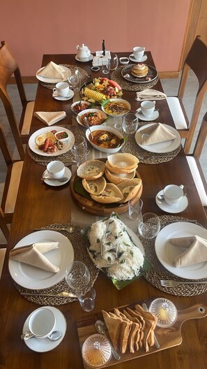 A dining table set with various dishes, including sandwiches, soup, and bread.