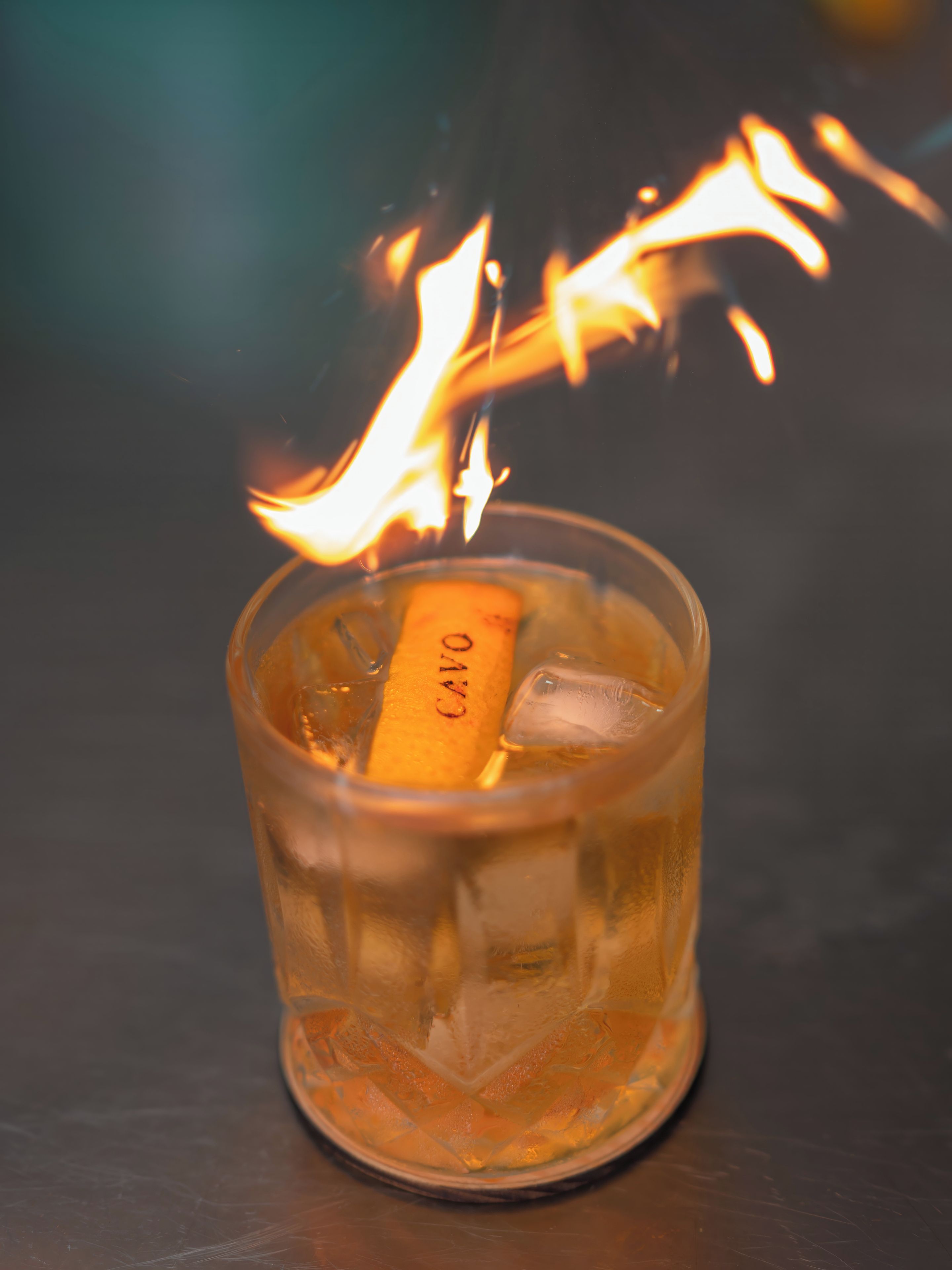 A glass with a lit candle and ice cubes.