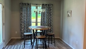 A dining area with a round table, four stools, and a chandelier. -  New, clean, spacious and cozy! Pet friendly!  (Broken Arrow)