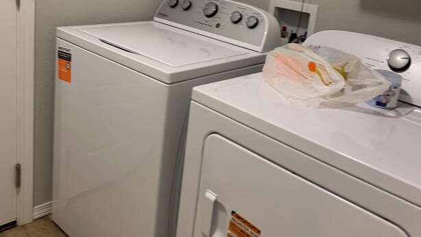 A laundry area with two white washing machines and a dryer, a white door, and a white wall. -  New, clean, spacious and cozy! Pet friendly!  (Broken Arrow)