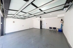 A spacious indoor area with a flat floor, a door, and a ceiling with skylights. - Modern Coastal Luxury, Ocean views, garage parking (San Diego)