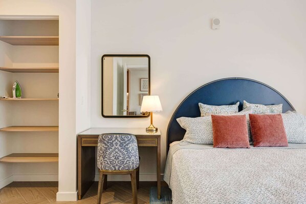 A hotel room with a bed, a desk, a chair, a lamp, and a wardrobe. - Miami 1BR Apartment with Pool Ideal for 3 Guests (Miami)
