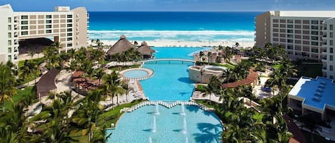A resort with a central pool, beachfront, and multiple buildings.
