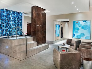 A modern lobby with a blue-tiled wall, a staircase, and a seating area with a coffee table. - Cancun Two Bedroom Villa Westin Lagunamar Resort (Cancún)