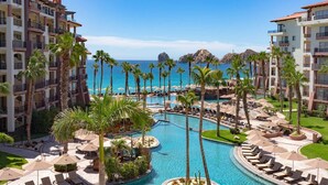 Et resort med flere swimmingpools, palmer og havudsigt.