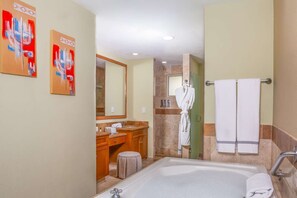 Un baño moderno con bañera, tocador y perchero para bata.