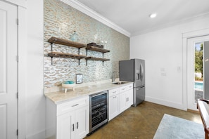 A modern kitchen with white cabinetry, a brick backsplash, and a stainless steel refrigerator. - Professionally Decorated with LSV and Pool (Seacrest Beach)