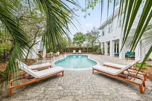 A swimming pool with lounge chairs, surrounded by a paved patio and greenery. - Professionally Decorated with LSV and Pool (Seacrest Beach)