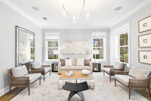A spacious living room with a neutral color palette, featuring a large sofa, two armchairs, a coffee table, and a chandelier. - Professionally Decorated with LSV and Pool (Seacrest Beach)