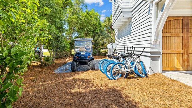A vehicle parked in a driveway with a bicycle rack attached to a building. - Professionally Decorated with LSV and Pool (Seacrest Beach)