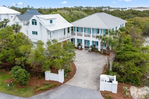 A large white house with a covered porch and a paved driveway. - Professionally Decorated with LSV and Pool (Seacrest Beach)