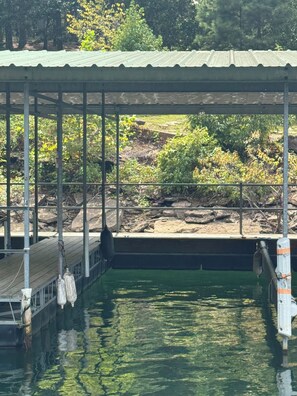 Une zone abritée avec un quai et une piscine, entourée de verdure et d’arbres.
