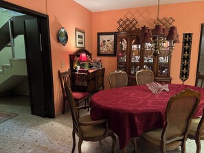 A dining room with a round table covered in a red tablecloth, surrounded by wooden chairs with cushioned seats. - Serviced, 4 BR House in Chapalita, near Expo (Guadalajara)