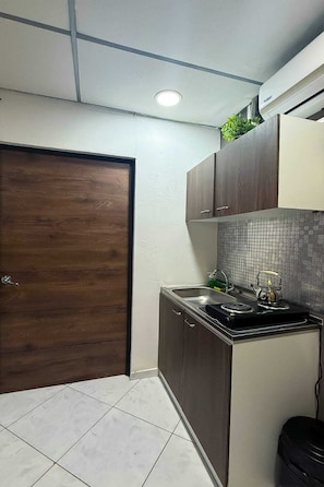 A compact kitchen with a stove, sink, and cabinets.
