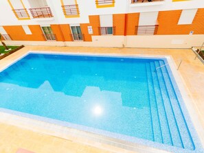 A rectangular indoor swimming pool with a tiled edge, surrounded by a tiled deck area. - Quinta Gomeira - Top Floor 2 Bedroom with pool (Cabanas de Tavira)