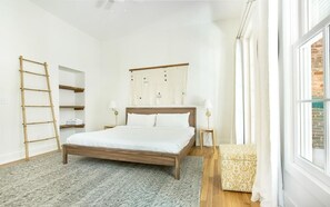 A bedroom with a wooden bed, a ladder, a wardrobe, and a window. - Park House Parlor Level - 2 Bedroom/2 Bath Overlooking Monterey Square (Savannah)