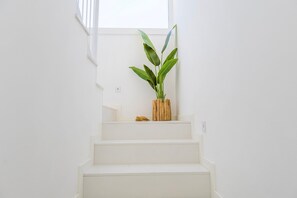 Een trap met een plant in een houten vaas aan de bovenkant.