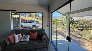 A modern interior with a sofa and a glass door leading to an outdoor area.