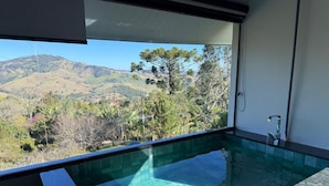 A private outdoor hot tub with a view of a mountainous landscape.