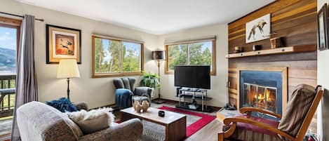 A living room with a fireplace, a television, and a sofa.