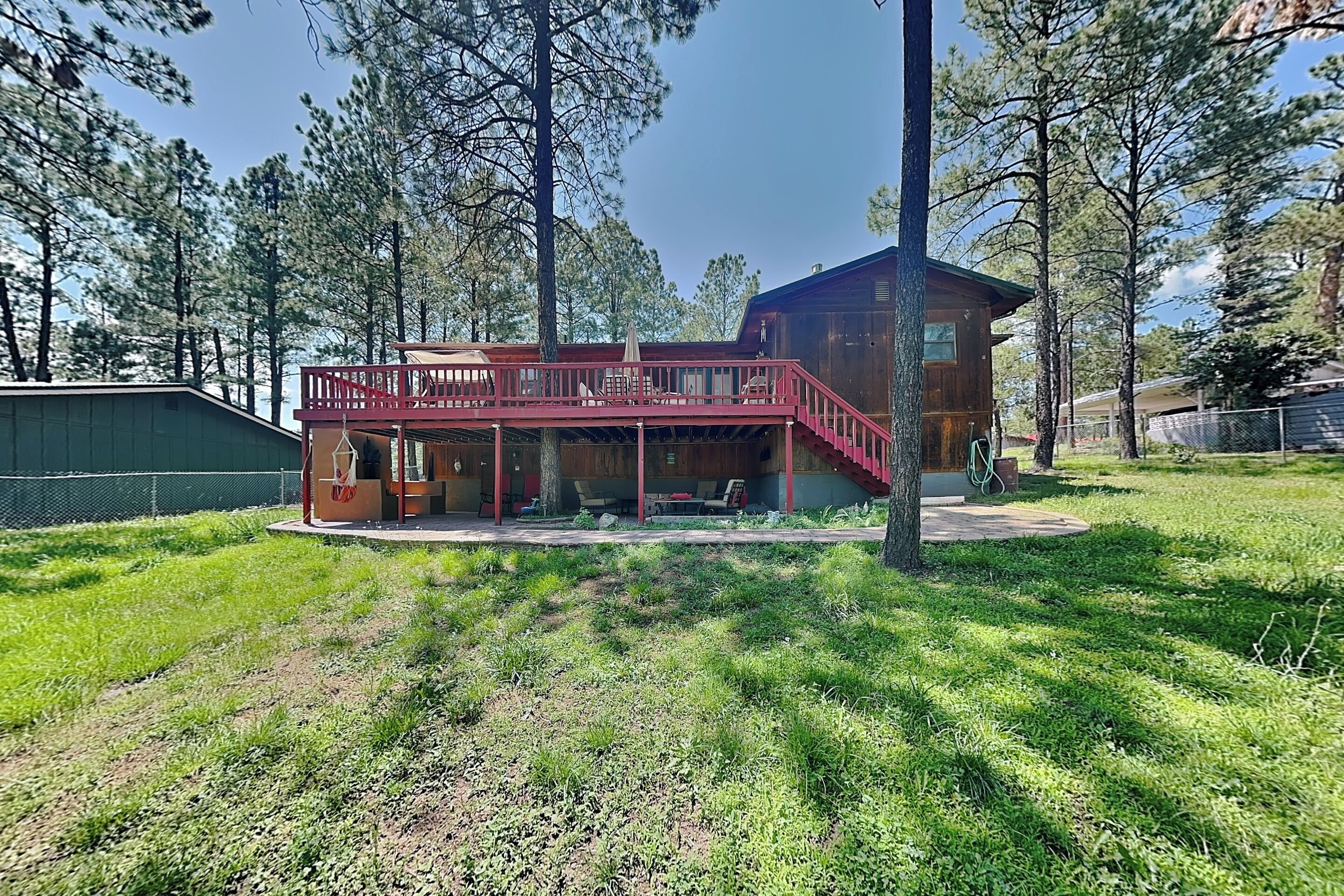 A wooden cabin with a covered porch and a staircase leading to a deck.