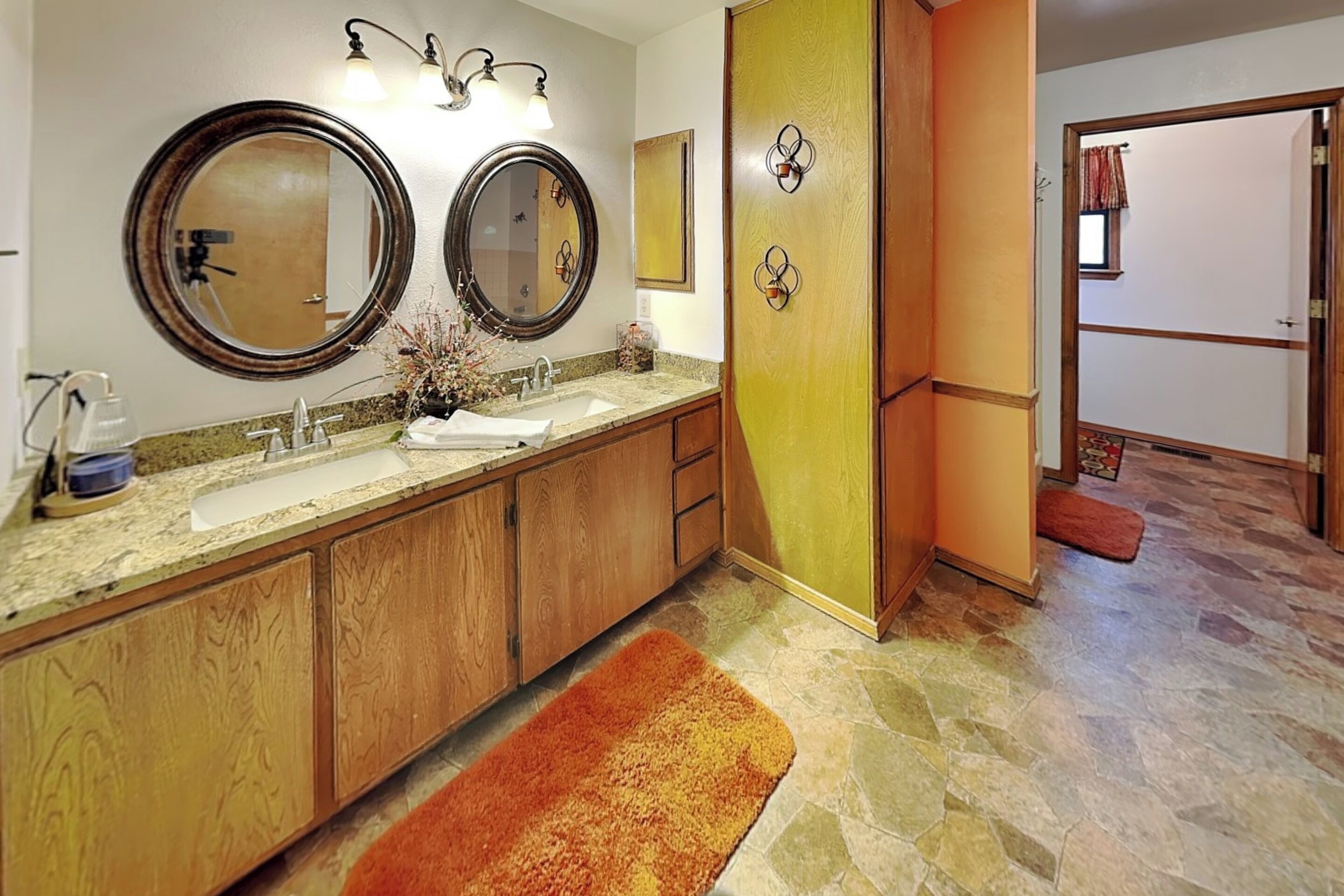 A bathroom with two sinks, a mirror, and a shower area.