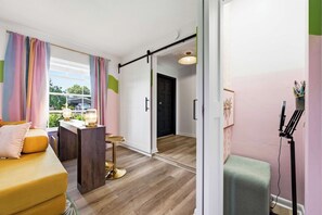 A modern room with a sofa, a desk, and a chair. There is a door leading to another room. - Pool •  Hot Tub•  Putt Putt • Game Room •  Karaoke (Largo)
