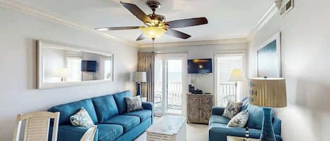 A living room with a ceiling fan, two sofas, a coffee table, and a TV.