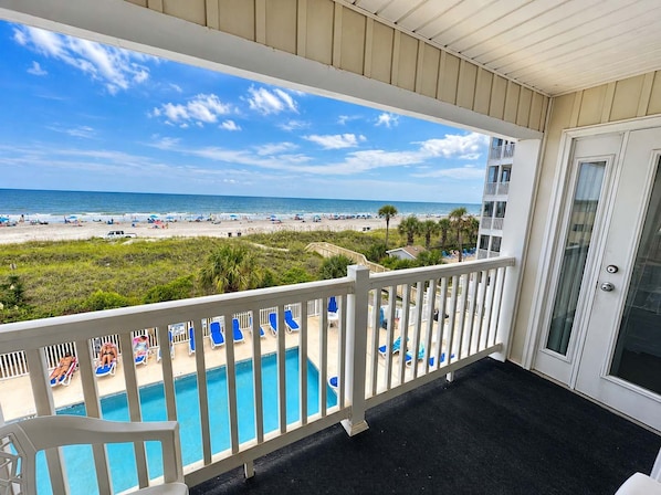 A balcony with a view of a beach and a pool area. - A Place at the Beach V - A307 (Myrtle Beach)