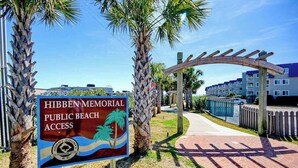 A sign for Hibben Memorial Public Beach Access with a clear pathway leading to a wooden archway. - Arcadian Dunes 02-207 (Myrtle Beach)