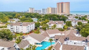 A residential area with multiple-story buildings, a swimming pool, and a view of the ocean. - Arcadian Dunes 02-208 (Myrtle Beach)
