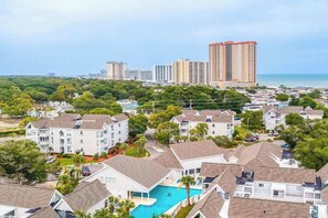 A residential area with multiple-story buildings, a swimming pool, and a view of the ocean. - Arcadian Dunes 02-208 (Myrtle Beach)