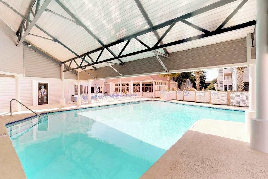 Ein überdachter Innenpool mit Liegestühlen und einer Poolanlage.