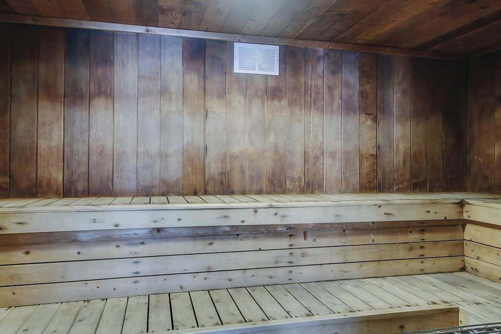 A wooden sauna with benches and a ventilation vent.