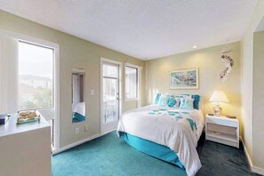 A bedroom with a bed, bedside table, lamp, and a window with a view. - Arcadian Dunes 02-208 (Myrtle Beach)