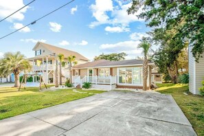 A two-story house with a front porch, a covered patio, and a well-maintained lawn. - Cozy Beach House 314 (North Myrtle Beach)
