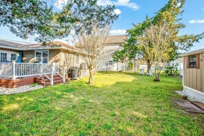 A residential property with a fenced yard, a wooden deck, and a small tree. - Cozy Beach House 314 (North Myrtle Beach)