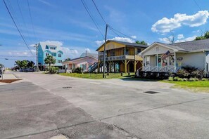 A residential street with houses, a clear sky, and a sidewalk. - Ocean Gem (North Myrtle Beach)