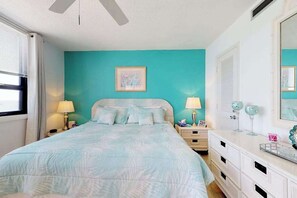 A bedroom with a bed, bedside lamps, a dresser, and a mirror. - Oceanfront Arcadian II  8D (Myrtle Beach)