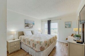 Ein Schlafzimmer mit einem Bett, einem Nachttisch und einem Fenster mit Vorhängen.
