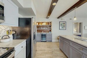 Eine moderne Küche mit Einbaukühlschrank, Holzschränken und einer Kochinsel.