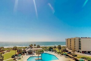 A resort with a swimming pool, beachfront view, and a building with multiple floors. - Palmetto Sunrise Waterfront Condo (Litchfield Beach)