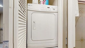A white washing machine in a room with a door partially open. - Arcadian Dunes 19-374 (Myrtle Beach)