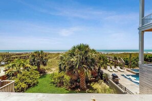 A beachfront property with a pool, palm trees, and a view of the ocean. - Ocean Views at The Beach (North Myrtle Beach)