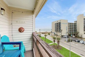 A balcony with a view of the beach and a hotel building labeled 'North Shore' in the background. - Sea Turtle Ocean View Condo (Myrtle Beach)
