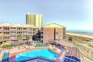 Ein Hotel mit Pool, Meerblick und mehreren Balkonen.