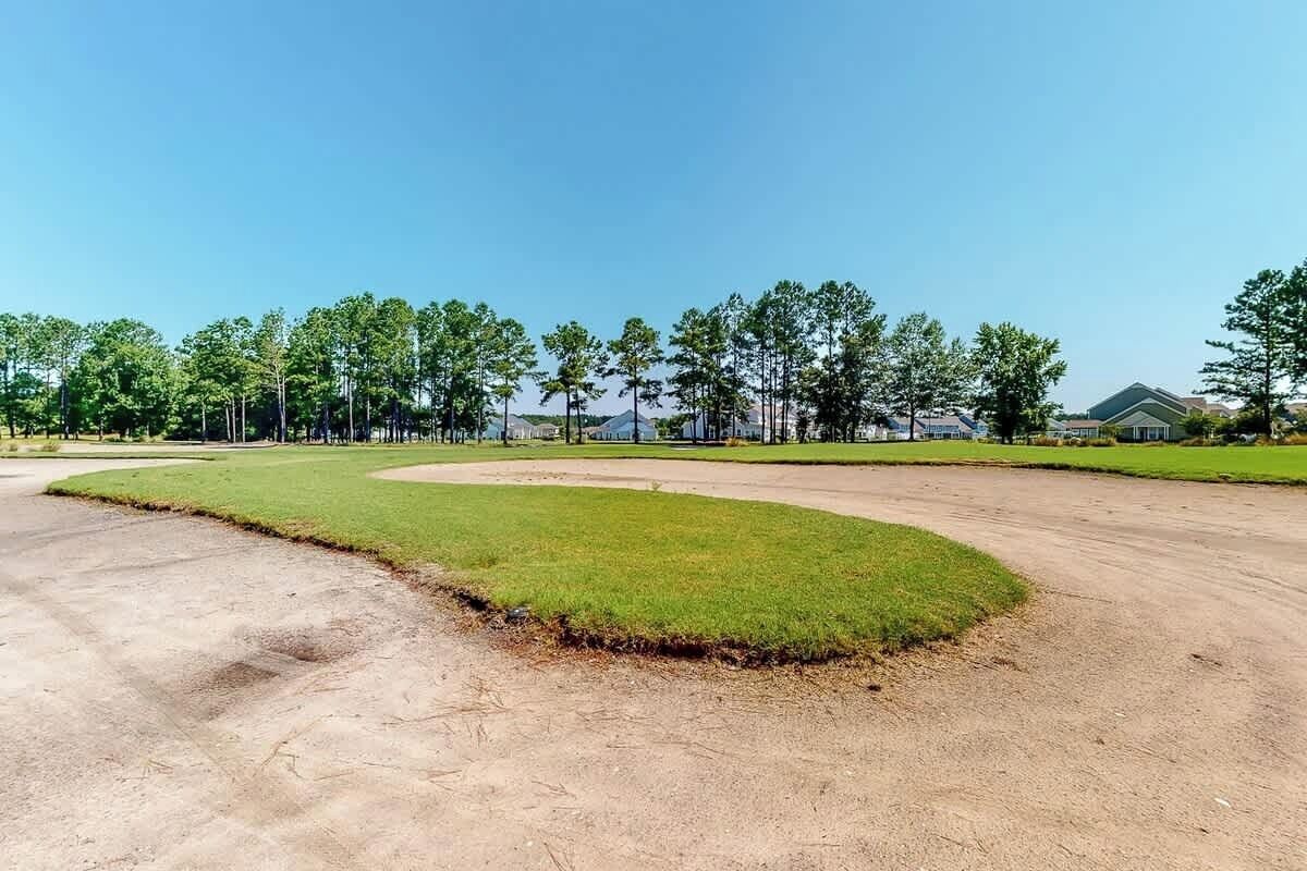 A large open area with a curved dirt path and a grassy section.