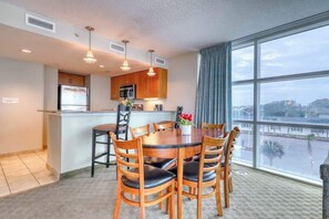 A modern kitchen with a dining area, large windows, and a view of the outside. - Sandy Beach Resort 304 (Myrtle Beach)